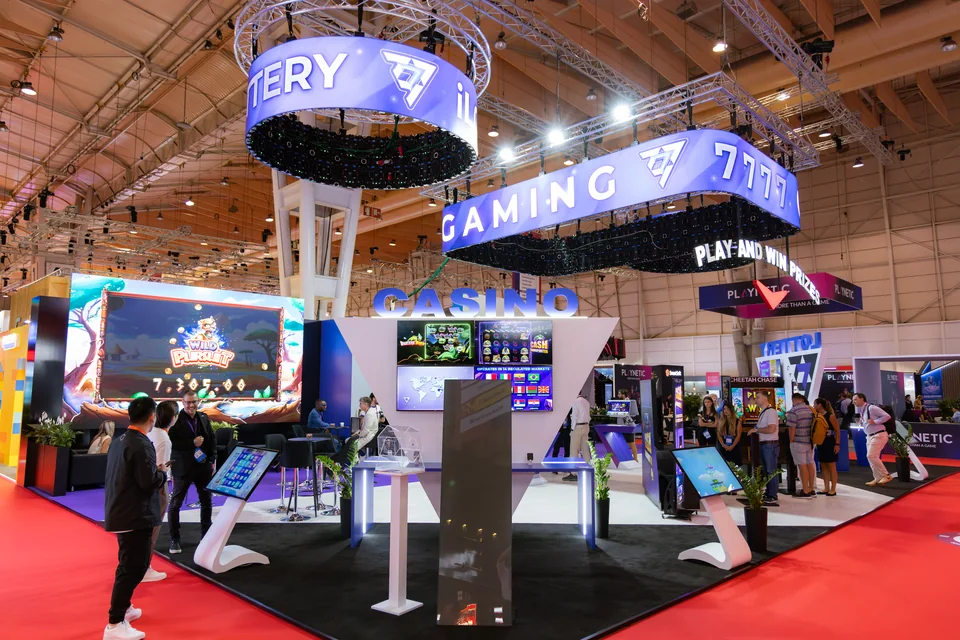 Circular LED installations above the 7777 Gaming stand at SBC Summit Lisbon 2025